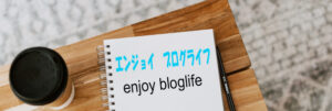 机上に置かれたスケッチブックにエンジョイ　ブログライフと書いてある