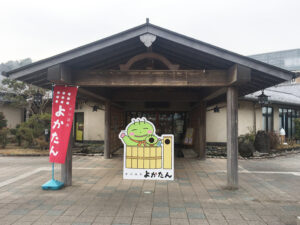 よかたん温泉（吉川温泉）の看板と赤色に「よかたん」ののばりが設置されたエントランス