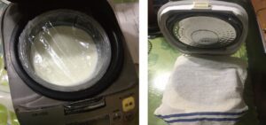炊飯器にラップをした牛乳をいれた容器をセットして布巾を上から被せる