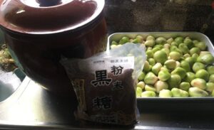 壺とトレーに入れたニンニクに粉末のビニールに入った黒糖