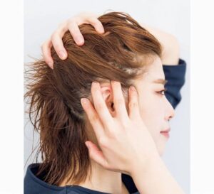 右手を頭に左手を頬の手を当てた横顔の女性