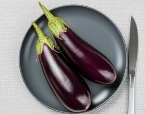 黒い皿も盛られた二本のナスの画像
