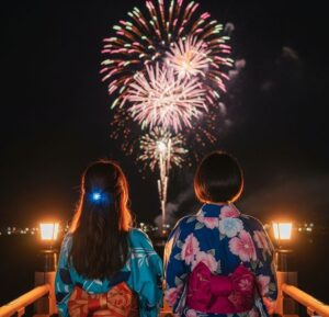 浴衣を着た女性２人が打ち上げ花火をみている後ろ姿