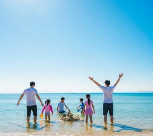 海辺で家族で砂遊びをしている画像