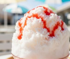 ふわふわのかき氷にストロベリーのシロップが掛っている画像
