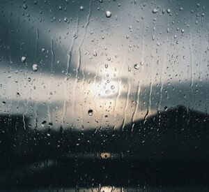 室内から雨が降っている外のうす暗い画像