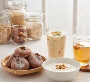 温かみのある木製のカッティングボードの上に、一口サイズにカットされた干し柿が美しく並べられている画像