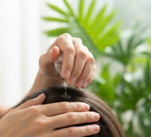 自然光が差し込む中で、手のひらに取られた育毛剤と、頭皮を優しくケアする指先をクローズアップしたイメージ