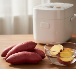 新鮮な栗かぐやが数本、木のテーブルに置かれている。その隣には、カットされて水にさらされた栗かぐやの輪切りがボウルに入っている画像