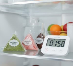 冷蔵庫で解凍中のおむすびケーキとタイマー