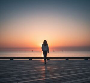 ウォーキングがもたらす心の安定とリフレッシュを表現しました。海沿いの遊歩道を、夕暮れ時に一人でゆっくりと歩く人の後ろ姿