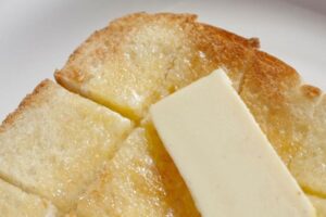 食パンにバターを塗っている画像