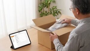到着してTEMの商品をケースから取り出している画層